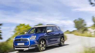 Mini Countryman E Elektro-SUV in blauer Lackierung bei Fahrt auf kurviger Landstraße