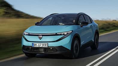 Nissan Leaf Elektroauto in Türkis bei Fahrt auf Landstraße mit modernem LED-Frontdesign