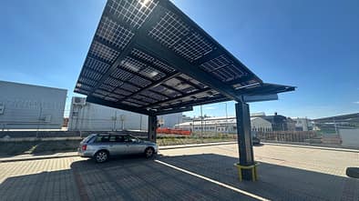 Solarcarport mit Photovoltaikmodulen auf einem Gewerbeparkplatz. Fehler bei Baugrund, Statik und Netzanschluss können Projekte verteuern.