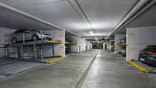 Duplex-Parksystem in einer Tiefgarage mit geparkten Fahrzeugen auf zwei Ebenen und nummerierten Stellplaetzen