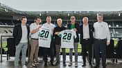 Vertreter von akf-Mobility und Borussia Mönchengladbach präsentieren im Stadion zwei Trikots zur neuen Mobilitätspartnerschaft.